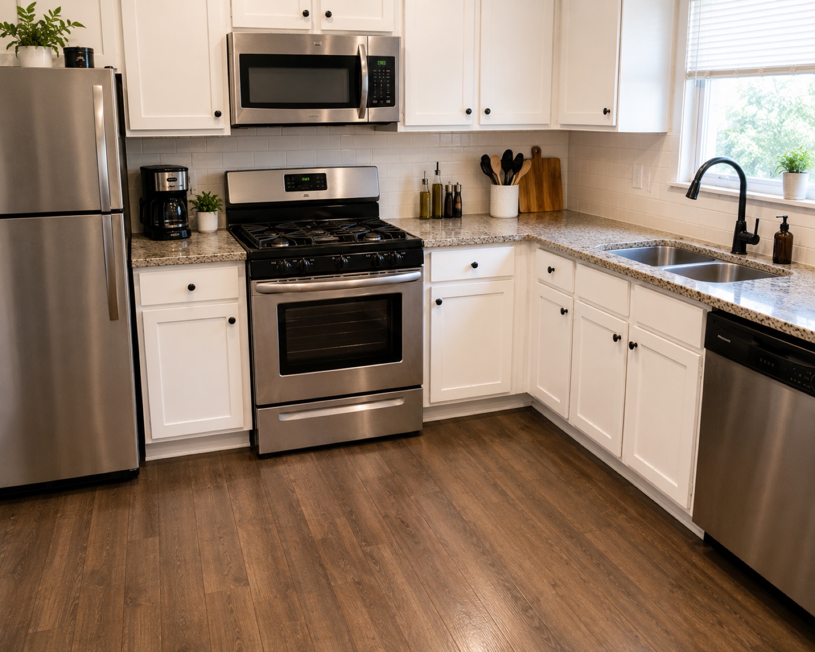 The same kitchen after a deep clean, with degreased cabinets, clear worktops and a mopped floor