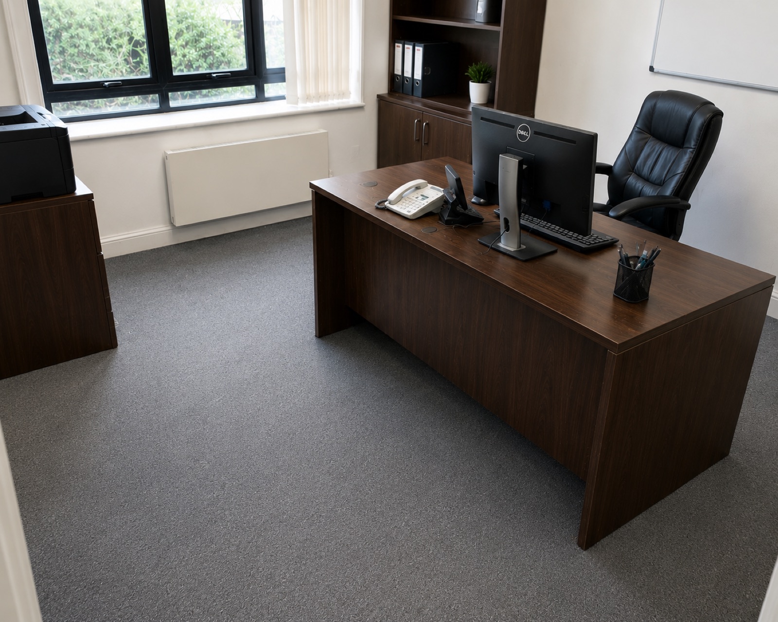 The same office after a deep clean, with a clear desk and the carpet cleaned throughout