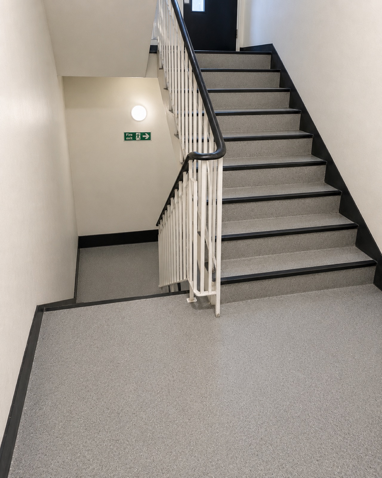The same stairwell after cleaning, with the treads, landing and handrail brought back